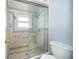 Bathroom featuring a shower room, commode, and a clear glass sliding door at 201 Twelve League Cir, Casselberry, FL 32707