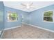 Light blue bedroom featuring tile floors, two windows, and a mirrored closet, offering ample natural light at 201 Twelve League Cir, Casselberry, FL 32707