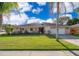Charming single-story home with a well-manicured lawn, mature palm trees, and a two-car garage at 201 Twelve League Cir, Casselberry, FL 32707
