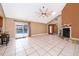 Open living room with tile floors, a fireplace, and a view of the pool through sliding glass doors at 201 Twelve League Cir, Casselberry, FL 32707