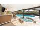 Beautiful outdoor pool area featuring an inset hot tub and a shaded bar area for entertaining at 201 Twelve League Cir, Casselberry, FL 32707