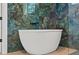 Soaking tub with blue marble backdrop for spa-like serenity at 20446 Quinlan St, Orlando, FL 32833