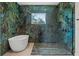 Luxurious bathroom with soaking tub, glass enclosed shower and unique green marbled walls at 20446 Quinlan St, Orlando, FL 32833