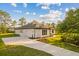 Modern white home with a two-car garage and a spacious concrete driveway and beautiful landscaping at 20446 Quinlan St, Orlando, FL 32833