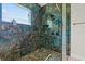 Stunning shower with luxurious blue marble walls, pebble tile floor, and glass enclosure at 20446 Quinlan St, Orlando, FL 32833