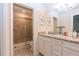 Bright bathroom featuring granite countertop, white cabinetry, and glass shower enclosure at 2123 Lelani Cir, Davenport, FL 33897