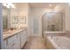 Spa-like bathroom featuring double vanity, soaking tub, and glass-enclosed shower at 2123 Lelani Cir, Davenport, FL 33897