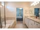 Bright bathroom with granite counters, dual sinks, soaking tub, glass shower, and view to the main bedroom at 2123 Lelani Cir, Davenport, FL 33897