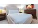 Bright bedroom featuring a plush bed, stylish side tables, and a modern TV above a wood dresser at 2123 Lelani Cir, Davenport, FL 33897