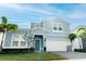Well-kept blue home featuring a two-car garage, manicured lawn, and bright natural lighting at 2123 Lelani Cir, Davenport, FL 33897