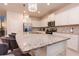 Bright kitchen features stainless steel appliances, white cabinets, and a large granite countertop island with pendant lighting at 2123 Lelani Cir, Davenport, FL 33897