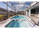 Screened-in pool and hot tub with paved deck, covered lanai, and privacy fence at 2123 Lelani Cir, Davenport, FL 33897
