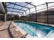 Backyard boasts large screened pool and spa surrounded by brick pavers at 2123 Lelani Cir, Davenport, FL 33897