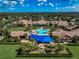Community clubhouse aerial view featuring a large pool and shaded seating areas amid lush landscaping at 223 Silver Maple Rd, Groveland, FL 34736