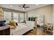 Cozy bedroom with a ceiling fan, large mirror, and modern decor at 223 Silver Maple Rd, Groveland, FL 34736