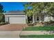 Charming home featuring a two-car garage, brick paved driveway and walkway, and manicured landscaping at 223 Silver Maple Rd, Groveland, FL 34736
