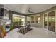 Enclosed patio features a ceiling fan, tile flooring, fireplace and a modern table setting for relaxation at 223 Silver Maple Rd, Groveland, FL 34736