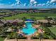 Stunning aerial view of the community pool with lush landscaping, sunshades and plenty of lounge chairs at 223 Silver Maple Rd, Groveland, FL 34736