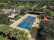 Aerial view of community tennis court featuring a shade structure and lush landscaping at 223 Silver Maple Rd, Groveland, FL 34736