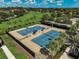 Aerial view of community tennis courts surrounded by mature trees and greenery at 223 Silver Maple Rd, Groveland, FL 34736