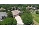 Aerial view of a home with a three-car garage surrounded by lush landscaping at 2332 Pond Cove Way, Apopka, FL 32712
