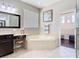A bathroom featuring a soaking tub, vanity, and entry to the walk in closet at 2332 Pond Cove Way, Apopka, FL 32712