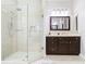 A bathroom featuring a walk-in shower with glass enclosure and a dark vanity at 2332 Pond Cove Way, Apopka, FL 32712