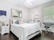 Comfortable bedroom with decoratively framed mirror and paintings that sits next to the desk with hardwood floors at 2332 Pond Cove Way, Apopka, FL 32712