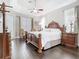 This hardwood-floored bedroom features unique vintage furniture that frames a queen sized bed under a ceiling fan at 2332 Pond Cove Way, Apopka, FL 32712