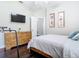 Well-lit bedroom with hardwood floors features an entertainment area, two matching paintings, and a comfortable queen size bed at 2332 Pond Cove Way, Apopka, FL 32712