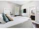 Cozy bedroom has a television, a walk in closet, and connects to the bathroom with plush decorative pillows at 2332 Pond Cove Way, Apopka, FL 32712