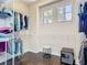 A walk-in closet with hanging racks, two windows, and wood floors at 2332 Pond Cove Way, Apopka, FL 32712