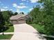 Charming home featuring a paved driveway, three-car garage, and beautifully landscaped front yard at 2332 Pond Cove Way, Apopka, FL 32712