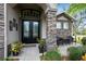 Charming front entrance with a double door, stone pillars, and a cozy outdoor seating area at 2332 Pond Cove Way, Apopka, FL 32712