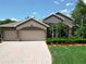 Beautiful home with a well-manicured lawn and a three-car garage, complemented by lush landscaping and a paver driveway at 2332 Pond Cove Way, Apopka, FL 32712