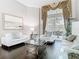 Bright living area with dark wood floors, white sofas, and a large window, creating an airy atmosphere at 2332 Pond Cove Way, Apopka, FL 32712