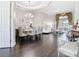 Bright living room featuring a glass dining table, dark wood floors, and a large window with designer drapes at 2332 Pond Cove Way, Apopka, FL 32712
