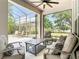 A covered patio with couches and chairs and a view of the backyard at 2332 Pond Cove Way, Apopka, FL 32712