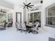 An outdoor patio space with seating, dining table, ceiling fans and an outdoor grill at 2332 Pond Cove Way, Apopka, FL 32712