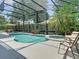 Beautiful screened-in pool area with lush landscaping and a relaxing spa at 2332 Pond Cove Way, Apopka, FL 32712