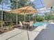Screened pool area with an umbrella-covered table for outdoor dining at 2332 Pond Cove Way, Apopka, FL 32712