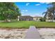 Expansive backyard showcasing lush green lawn, lake access, and a screened-in patio for outdoor enjoyment at 2501 Trentwood Blvd, Belle Isle, FL 32812