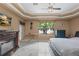Spacious main bedroom with a fireplace, ceiling fan, and large windows overlooking the backyard at 2501 Trentwood Blvd, Belle Isle, FL 32812