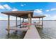 Stunning boathouse dock featuring a boat lift and an outdoor seating area perfect for relaxing by the water at 2501 Trentwood Blvd, Belle Isle, FL 32812