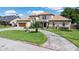 Charming home with a circular driveway, water fountain, and manicured lawn at 2501 Trentwood Blvd, Belle Isle, FL 32812