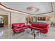View of the living room with two red couches, white tile floors, and a billiard table in the background at 2501 Trentwood Blvd, Belle Isle, FL 32812