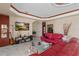 Bright living room features tile floors, a red leather sofa, and a large screen television at 2501 Trentwood Blvd, Belle Isle, FL 32812
