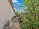 Well maintained side yard with stone walkway, plants, and air conditioner unit along the home's exterior at 2501 Trentwood Blvd, Belle Isle, FL 32812