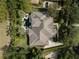 Aerial view of a luxurious home featuring an elaborate tile roof, well-kept landscaping, and a unique pool layout at 25519 Hawks Run Ln, Sorrento, FL 32776