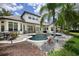 Backyard and pool area surrounded by tropical landscaping and a well-manicured lawn at 25519 Hawks Run Ln, Sorrento, FL 32776